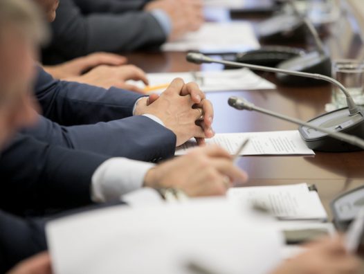 One,Of,Politician,Sitting,By,Table,With,His,Hands,Over